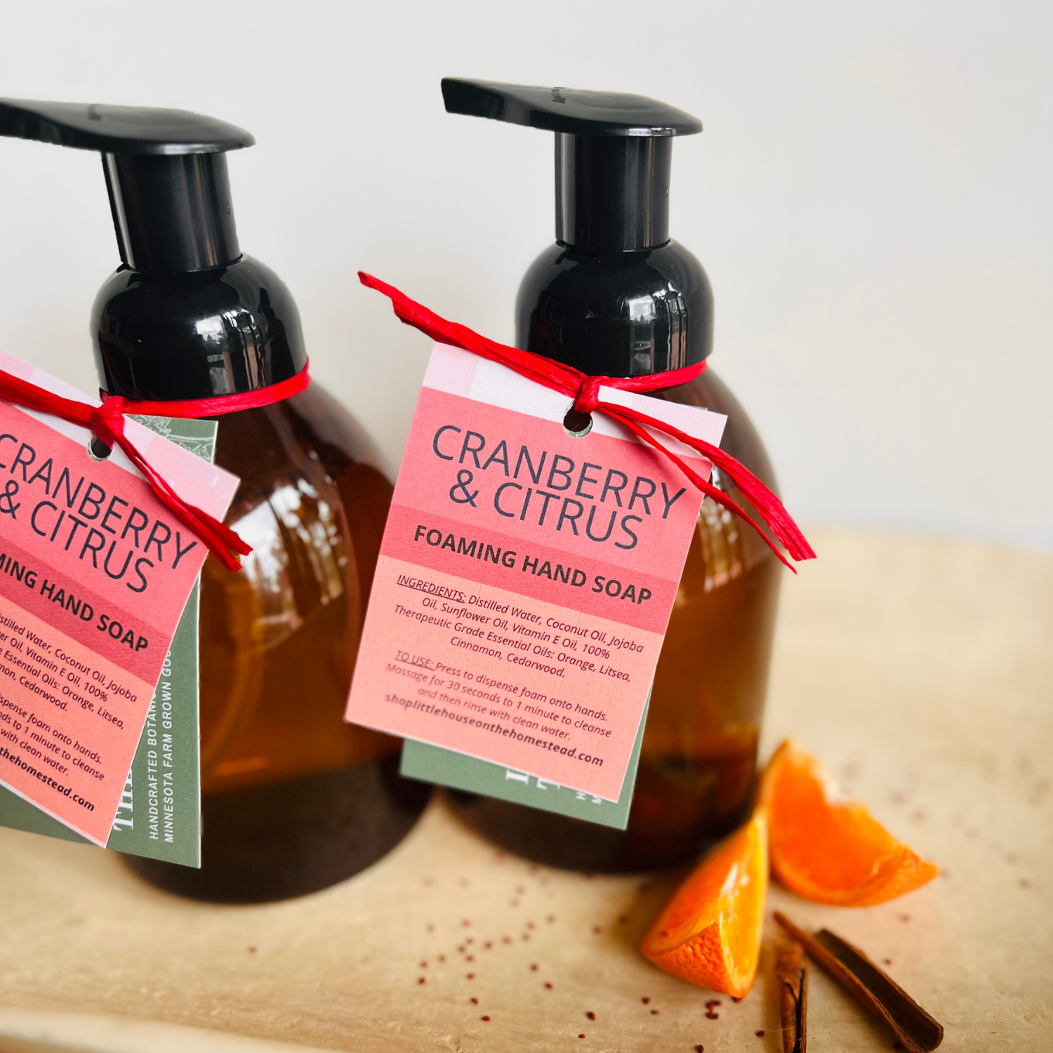 Foaming hand soap bottles styled with orange wedges and cinnamon sticks